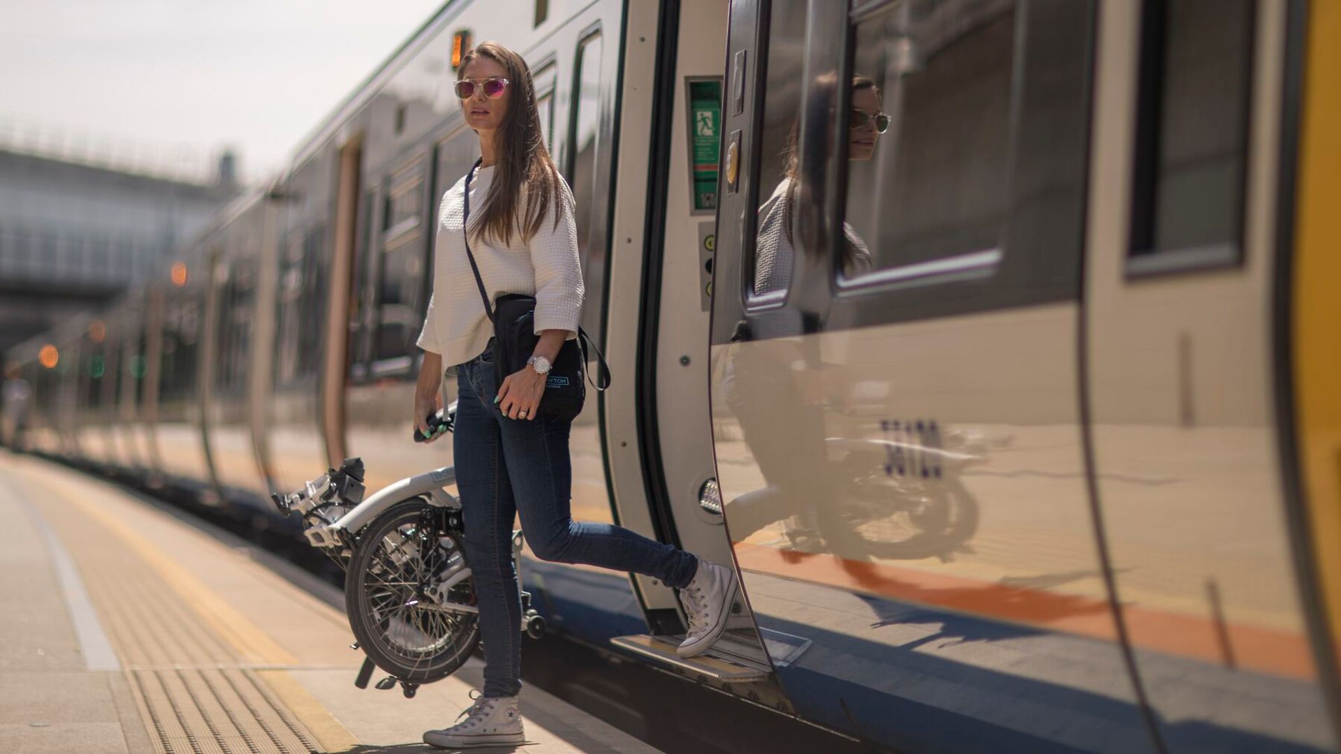 Frau mit Fahrrad aus dem Zug aussteigend