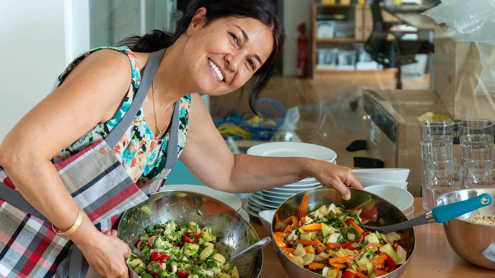 Frau in Kantinenküche mit frischem Salat