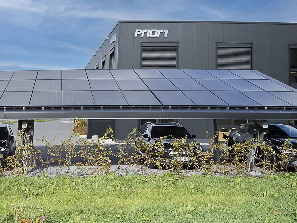 Carport mit Solarzellen auf Dach vor Firmenzentrale